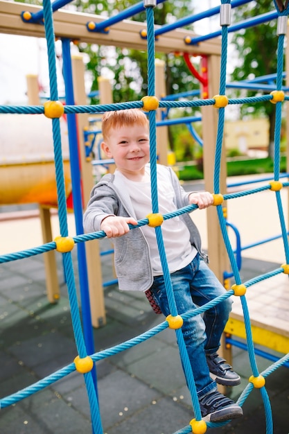 Ragazzino che gioca nel parco giochi.