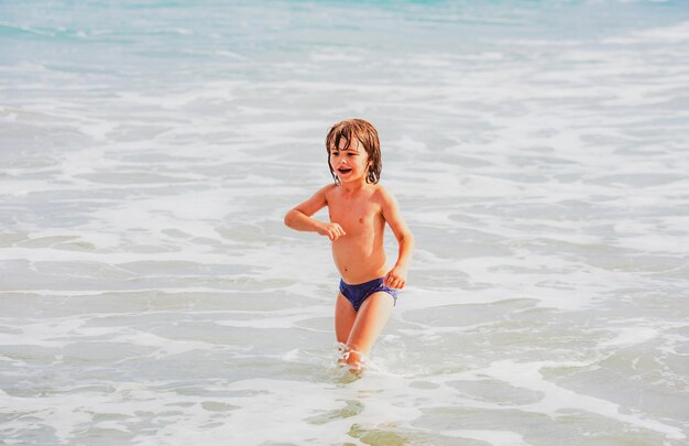 Ragazzino che gioca sulla spiaggia durante le vacanze estive bambini nella natura con un bellissimo mare bambini felici su ...