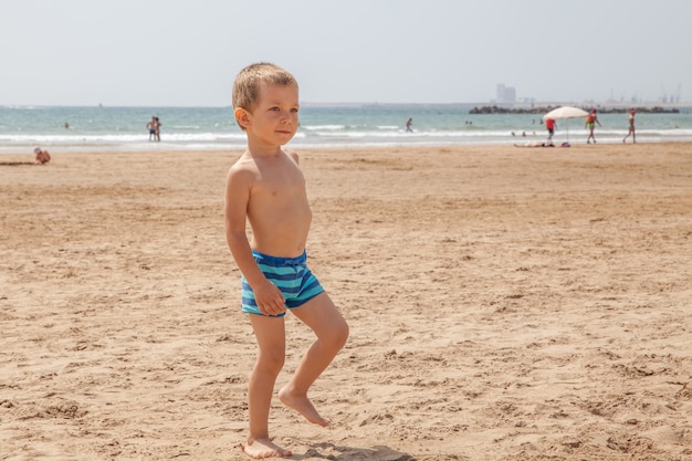 Ragazzino che gioca tra le onde in mare in una giornata di sole