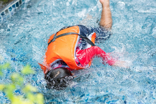 Ragazzino che ha avuto un incidente che cade o annega in piscina