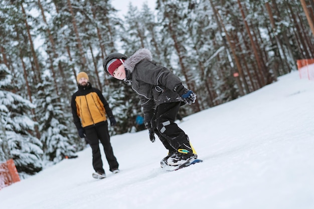 Ragazzino che impara a guidare sullo snowboard