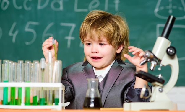 Ragazzino che impara la chimica in laboratorio Scienziato del bambino della scuola che studia scienza Attrezzatura del laboratorio della scuola di biologia Ragazzino alla scuola elementare Ragazzino alla lezione Ritorno a scuola