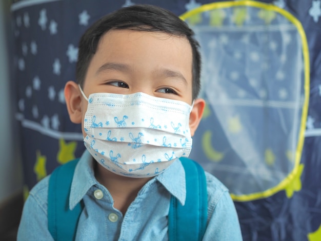 Ragazzino che indossa una maschera protettiva di protezione da virus o malati