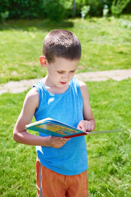 Ragazzino che legge libri all'aperto