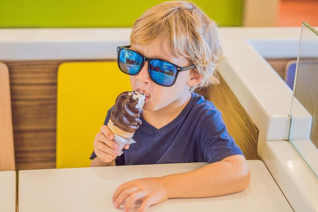 Ragazzino che mangia il gelato in un bar.