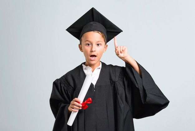 Ragazzino che si laurea con l&#39;intenzione di realizzare la soluzione su sfondo grigio