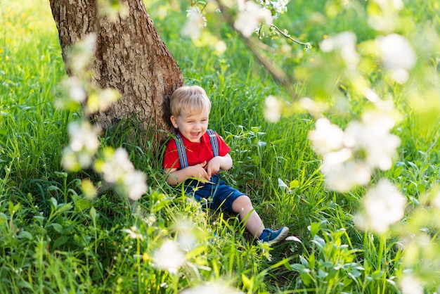 Ragazzino che si siede sotto un albero e che riposa