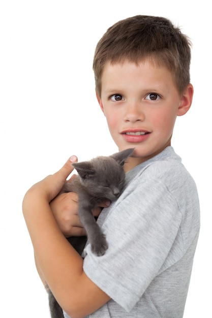 Ragazzino che tiene gattino grigio che sorride alla macchina fotografica