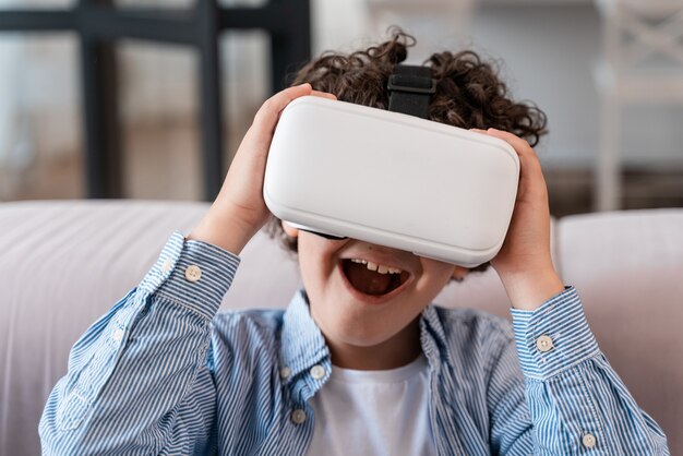 Ragazzino che usa gli occhiali vr. Concetto di infanzia e tecnologia