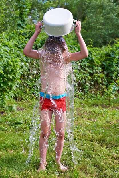 Ragazzino che versa acqua in estate