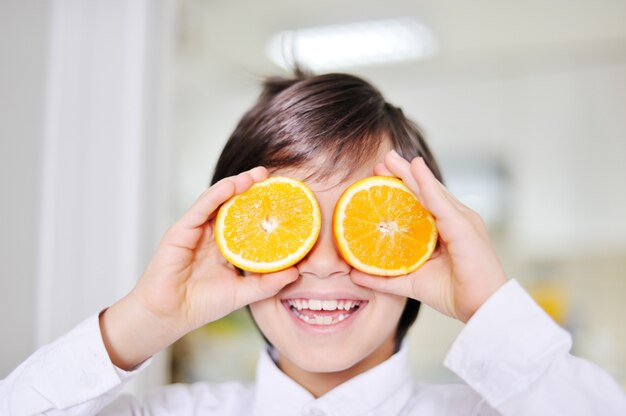 Ragazzino con arance come occhiali