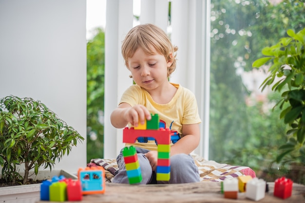 ragazzino con giocare con blocchi di plastica colorati al coperto