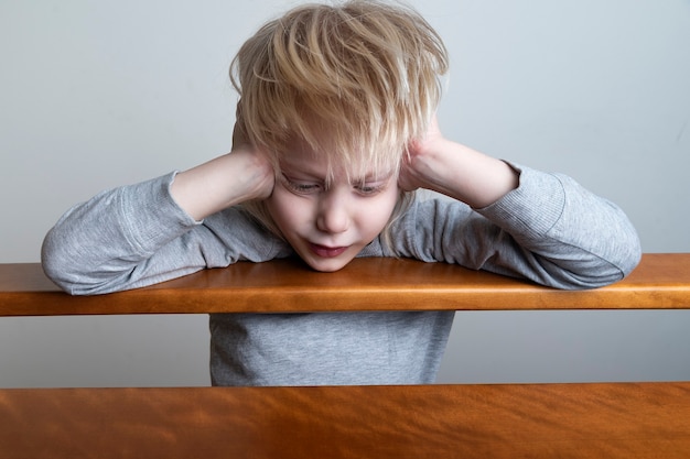 Ragazzino con i capelli biondi che gioca in casa