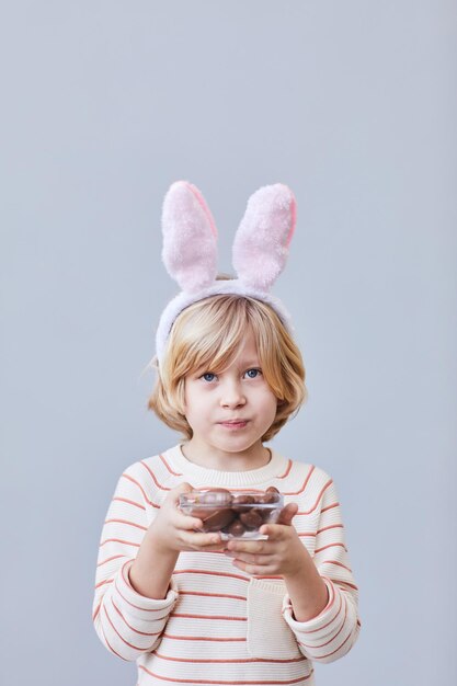 Ragazzino con le uova di Pasqua del cioccolato