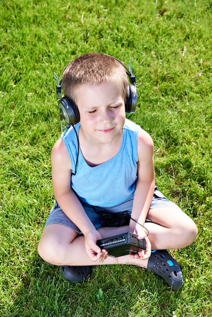 Ragazzino con lettore di cassette audio e cuffie