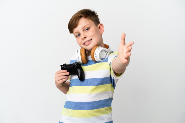 Ragazzino dai capelli rossi che tiene in mano un game pad isolato su sfondo bianco che stringe la mano per chiudere un buon affare