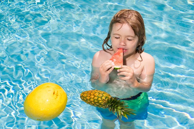Ragazzino divertente che si rilassa in una piscina divertendosi durante le vacanze estive in un resort tropicale