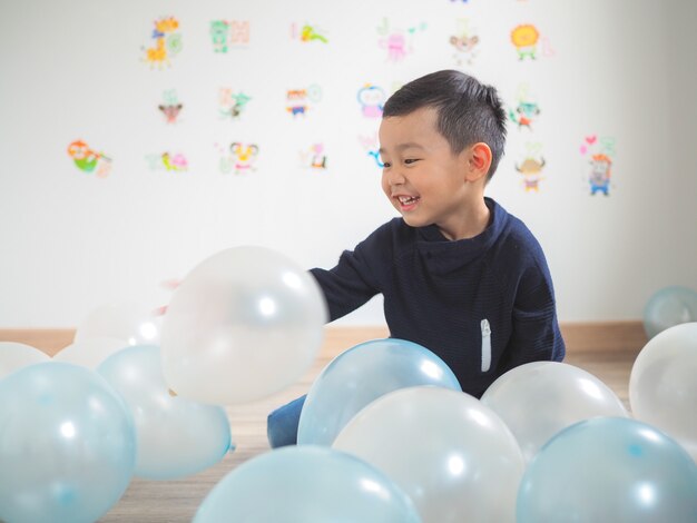 Ragazzino divertente gioca con palloncini colorati