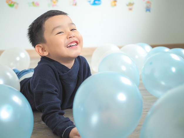 Ragazzino divertente gioca con palloncini colorati