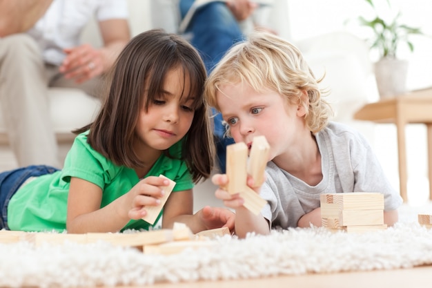 Ragazzino e ragazza che giocano insieme con i domino