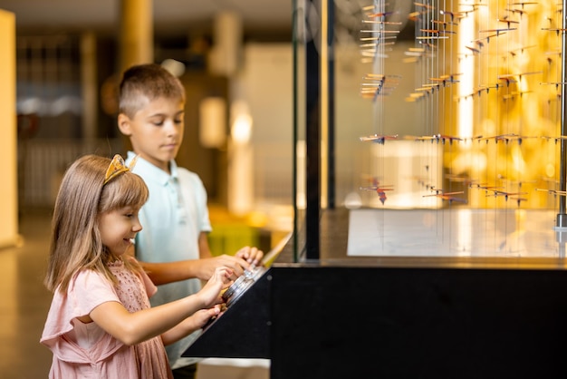 Ragazzino e ragazza che studiano fisica nel museo della scienza