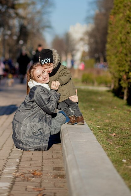 Ragazzino felice che bacia madre all'aperto