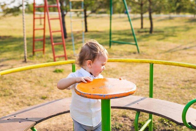 Ragazzino felice nel parco giochi durante il giorno.