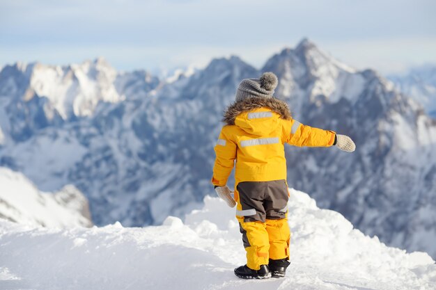 Ragazzino godendo la vista delle montagne Alp inverno.