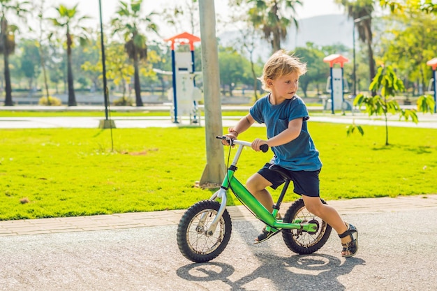 Ragazzino in bicicletta. Catturato in movimento, su un vialetto. Il primo giorno in bicicletta del bambino in età prescolare. La gioia del movimento. Il piccolo atleta impara a mantenere l'equilibrio mentre va in bicicletta