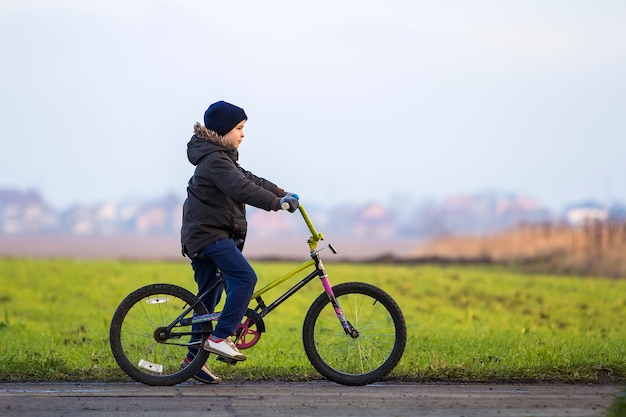 Ragazzino in bicicletta fuori. Bambino che gioca all'aperto