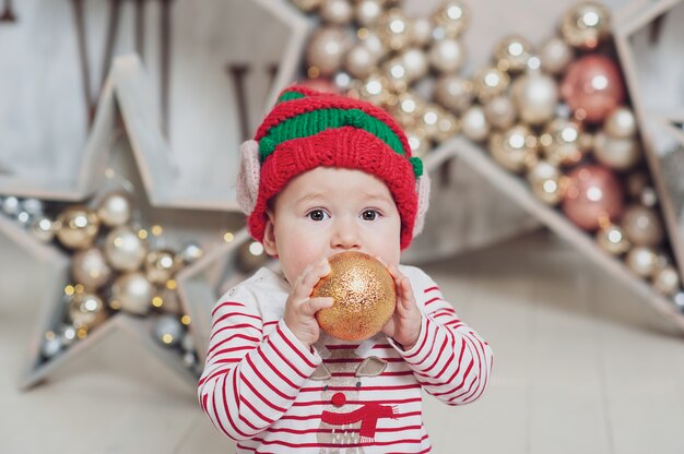 Ragazzino in cappello elfo in attesa di una decorazione dell&#39;albero di Natale,