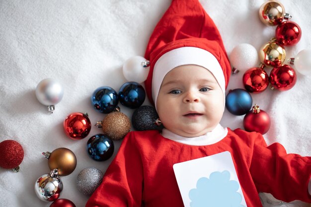 Ragazzino in costume da Babbo Natale con decorazioni natalizie.