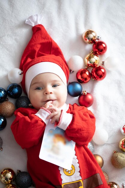 Ragazzino in costume da Babbo Natale con decorazioni natalizie.