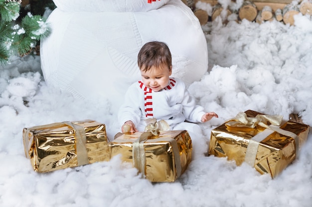 Ragazzino in costume pupazzo di neve seduto in un interno di casa dal grande pupazzo di neve e in attesa di Babbo Natale