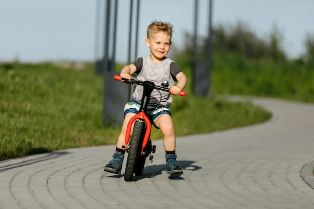 Ragazzino in sella a una bicicletta in un parco cittadino