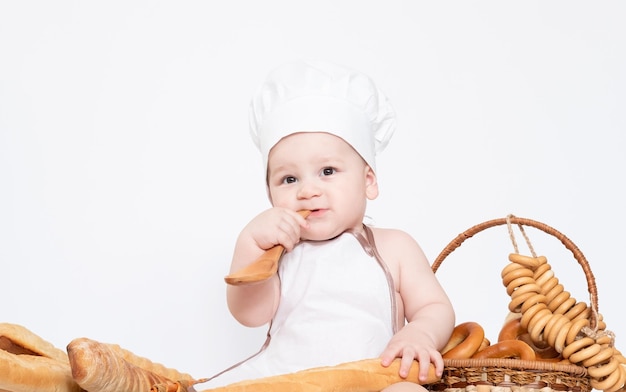 Ragazzino in un cappello da cuoco e con pane divertente piccolo chef