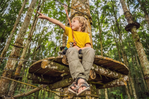 Ragazzino in un parco avventura Ricreazione fisica attiva del bambino all'aria aperta nel parco Formazione per bambini