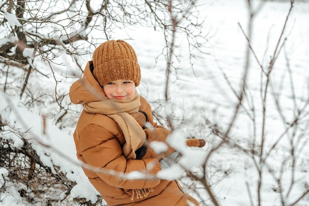 Ragazzino in un parco o in una foresta d'inverno