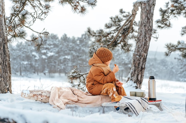 Ragazzino in un parco o in una foresta d'inverno