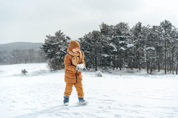 Ragazzino in un parco o in una foresta d'inverno