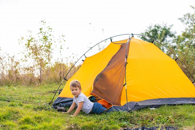 Ragazzino in una tenda. Campeggio nella natura.