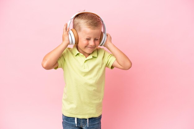 Ragazzino russo che ascolta la musica con le cuffie sopra fondo isolato