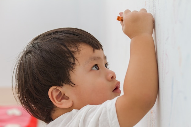 ragazzino scrivendo sullo sfondo del muro