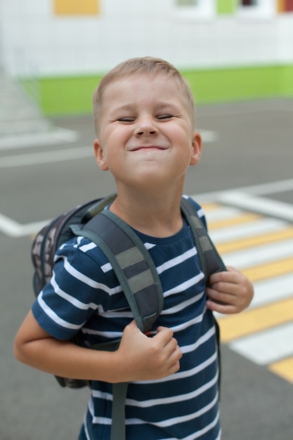 Ragazzino sorridente allegro con il grande zaino