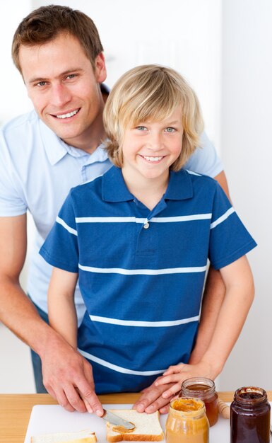 Ragazzino sorridente e suo padre preparando la colazione