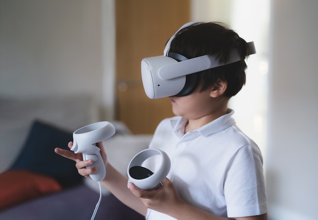Ragazzino stupito che indossa occhiali per realtà virtuale. Ragazzo emotivo che gioca ai videogiochi guardando in cuffia VR. Ritratto di ragazzo di razza mista che sperimenta gadget 3D in soggiorno.