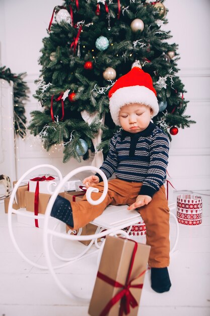 Ragazzino sullo sfondo dell'albero di Natale