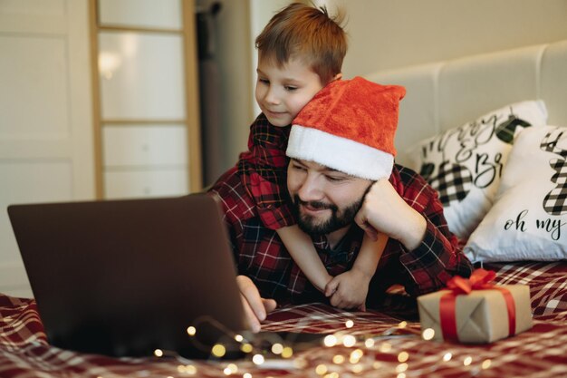 Ragazzino sveglio che abbraccia il cappello di santa faterin che compra regali per natale online