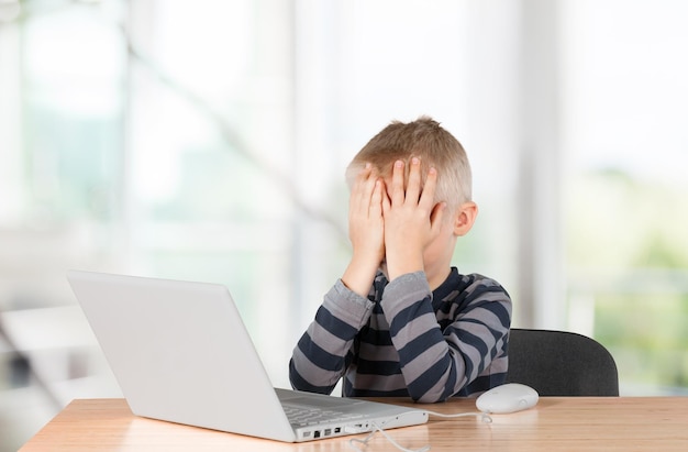 Ragazzino sveglio che gioca con il computer portatile