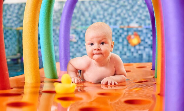 Ragazzino sveglio che gioca in piscina